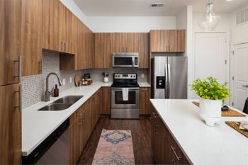 a modern kitchen with wooden cabinets and stainless steel appliances